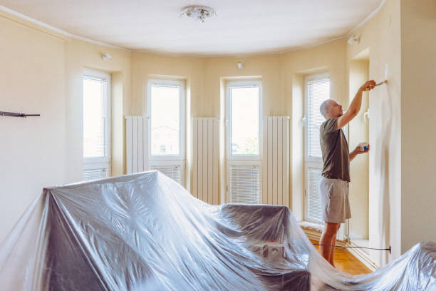 istock Young man repairing wall with plaster. 697764116