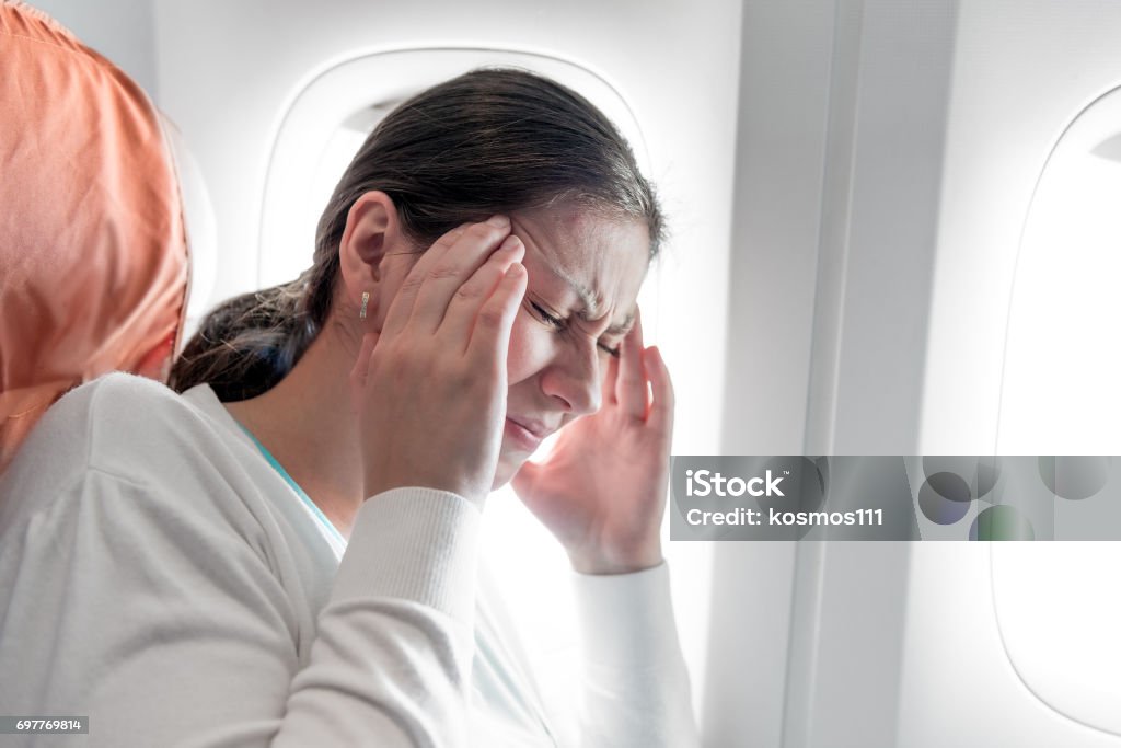 Portrait of a woman with a headache on an airplane Airplane Stock Photo