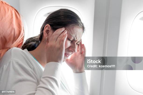 Portrait Of A Woman With A Headache On An Airplane Stock Photo - Download Image Now - Airplane, Fear, Women