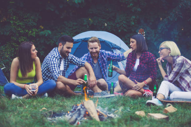 istock Friends chilling out on camping next to fireplace 697770304