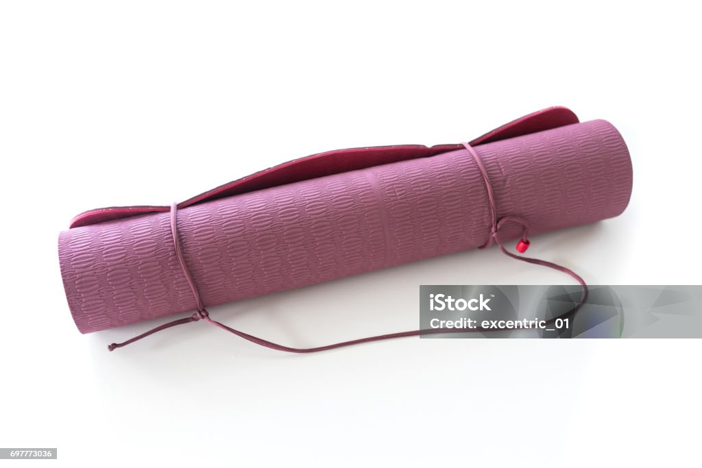 picture taken in ontario canada Still life, studio shot, of rolled up, purple, yoga mat against white background Exercise Mat Stock Photo