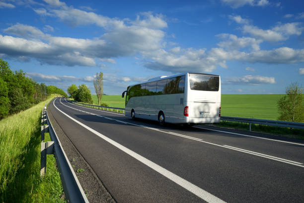 istock Bus traveling on the road along the green fields 697777162