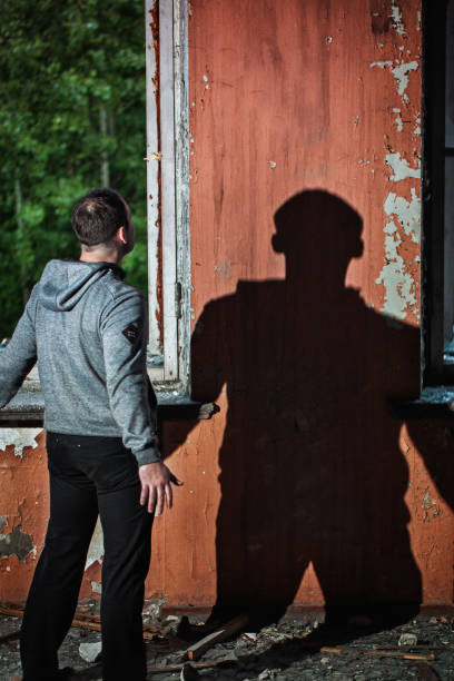 istock a Man in an Abandoned Building Looks at his Shadow 697791398