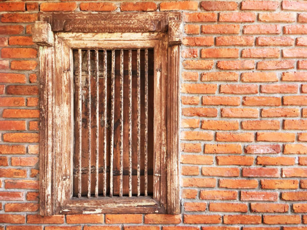 istock antique wooden window with iron bars on brick wall 697794962