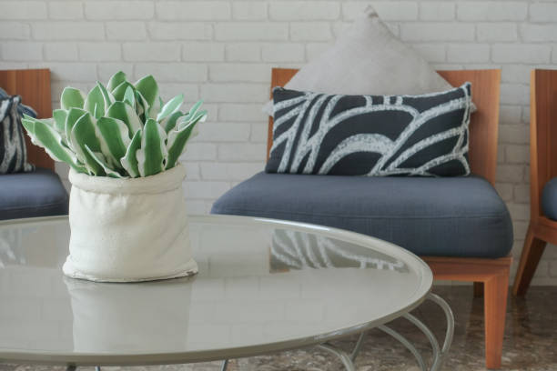 Decorative plant pot on center table with easy chair in background