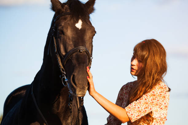 istock young woman standing with her horse 697801150