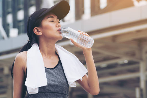 femme sport avec bouteille d’eau à boire - running jogging asian ethnicity women photos et images de collection