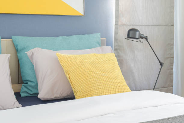 istock Yellow and green pillow on bed with black foldable lamp on bedside table in modern interior bedroom 697801988
