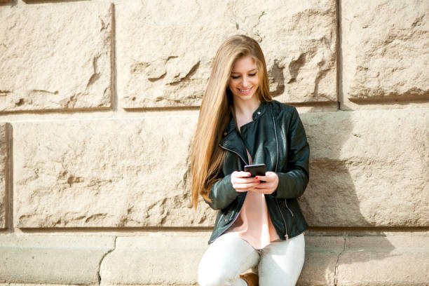istock Young woman texting on smart phone 697802194
