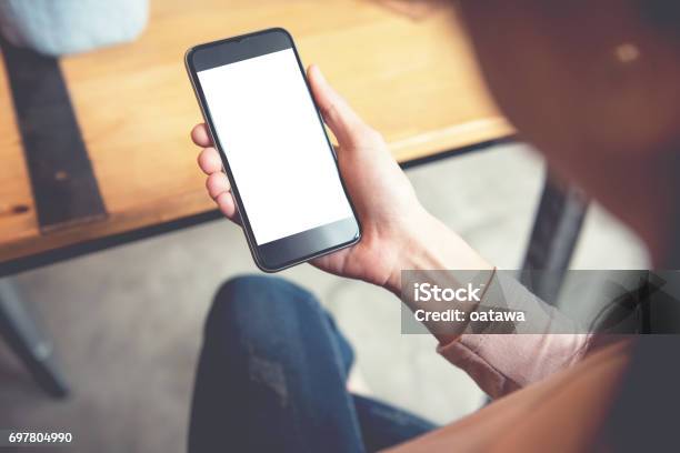 Woman Using Smart Phone In Cafe Hand Holding Smart Phone Stock Photo - Download Image Now