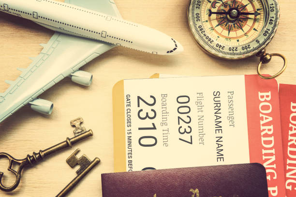 istock Two boarding passes with passports, vintage brass keys, a compass, a white model airplane on a table. 697805202