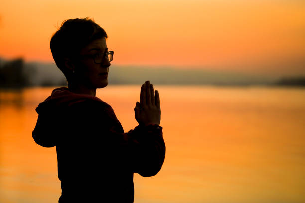 istock Silhouette of a woman meditating 697805324