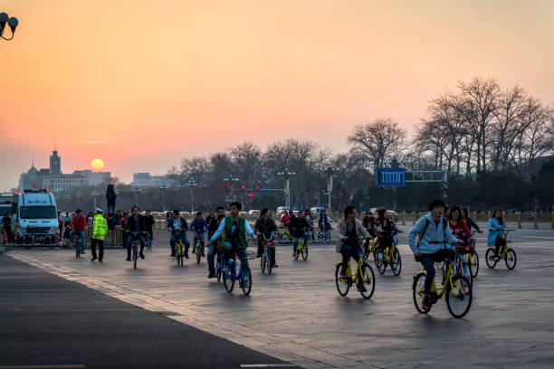 Cyclists at sunset, Tiananmen Square, Beijing, China