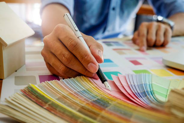 istock Graphic design and color swatches and pens on a desk. Architectural drawing with work tools and accessories. 697806104