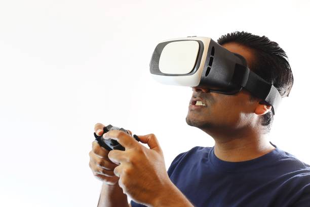 istock Young handsome man wearing virtual reality goggles standing against white background 697808274