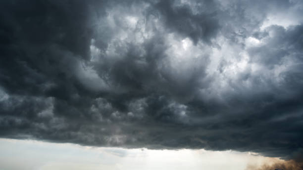istock clouds with background,sunlight through very dark clouds background of dark storm clouds,black sky Background of dark clouds before a thunder. 697809010
