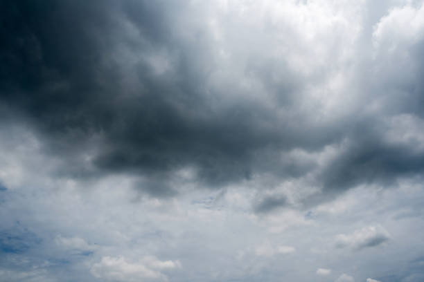 istock clouds with background,sunlight through very dark clouds background of dark storm clouds,black sky Background of dark clouds before a thunder. 697809146