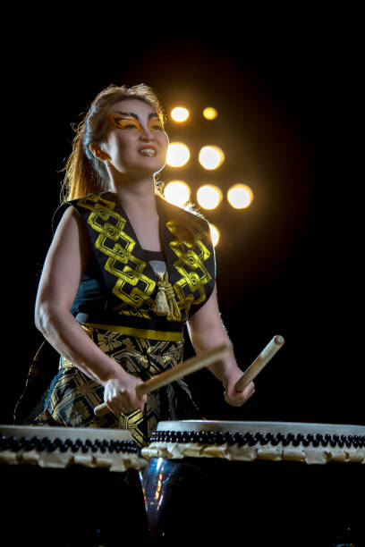 istock beautiful asian drummer girl with drumsticks, studio shot on a dark background. 697809640