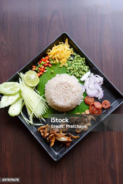Thai Food Rice Mixed With Shrimp Paste With Side Dish As A Mango Lemon Chili Cucumber Scrambled Egg Cowpea Shallots Chinese Sausage Dried Shrimp And Pork Stock Photo - Download Image Now