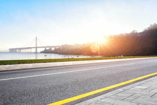 istock empty road near suspension bridge with sunbeam 697824110