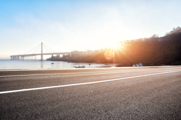 estrada vazia perto da ponte de suspensão com raio de sol - traffic car travel golden gate bridge - fotografias e filmes do acervo