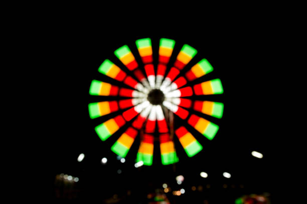 ruota panoramica molto sfocata - ferris wheel wheel night neon light foto e immagini stock