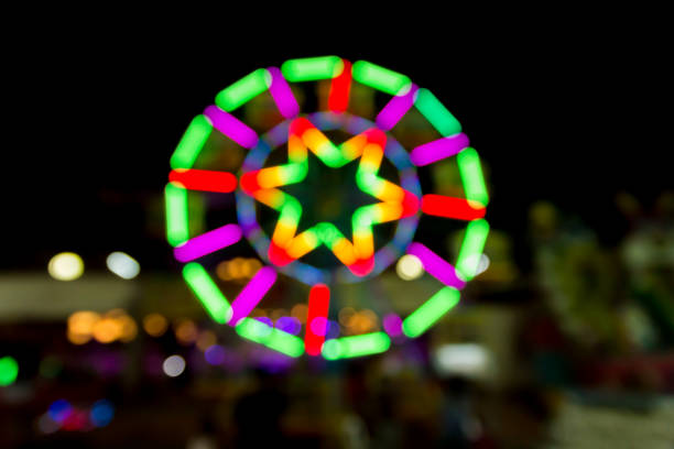 ruota panoramica molto sfocata - ferris wheel wheel night neon light foto e immagini stock