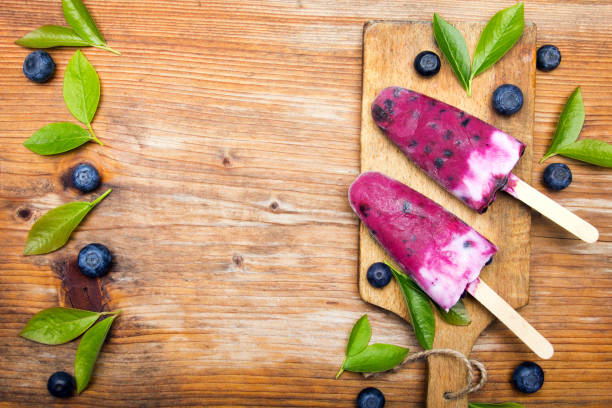 Tasty homemade blueberries ice cream on wooden background. Organic fruit popsicles.