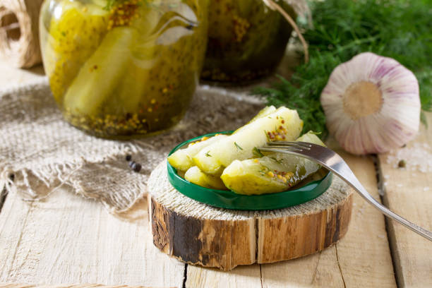 istock Marinated cucumbers gherkins. Marinated pickles with mustard and garlic on the kitchen table. 697837866