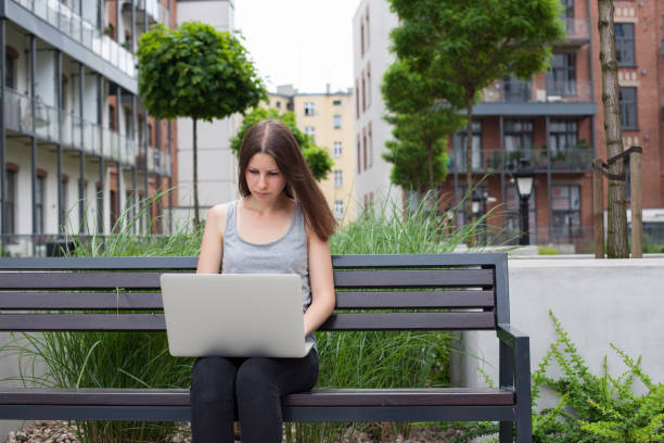 istock Young woman freelancer works with new silver laptop 697838288