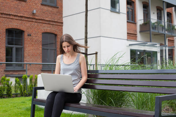 istock Young woman freelancer works with new silver laptop 697838388