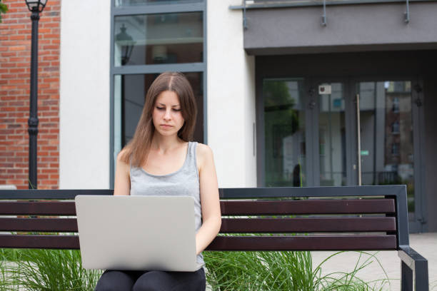 istock Young woman freelancer works with new silver laptop 697838396