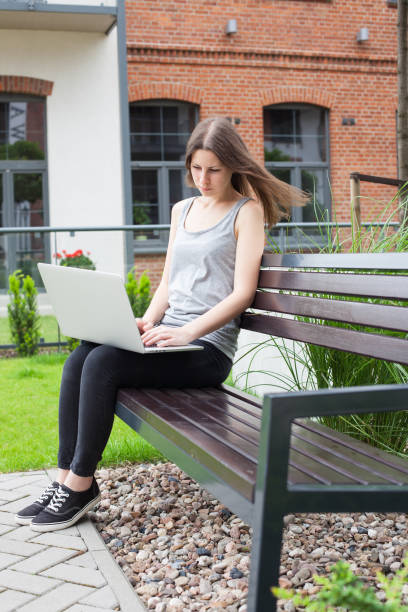istock Young woman freelancer works with new silver laptop 697838400