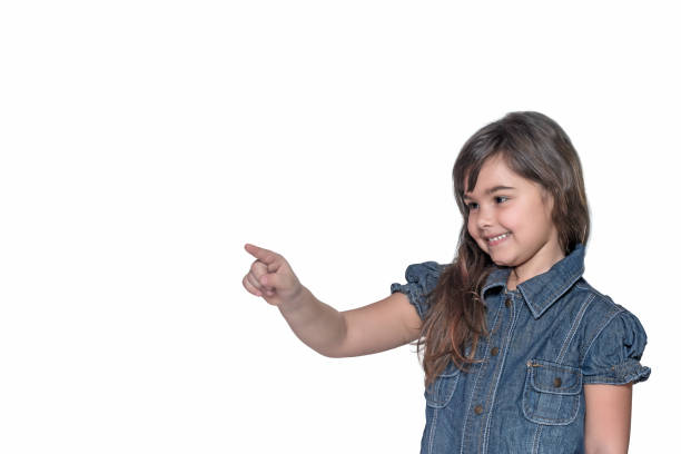 istock Smiling little girl is pointing her index finger into space 697839564