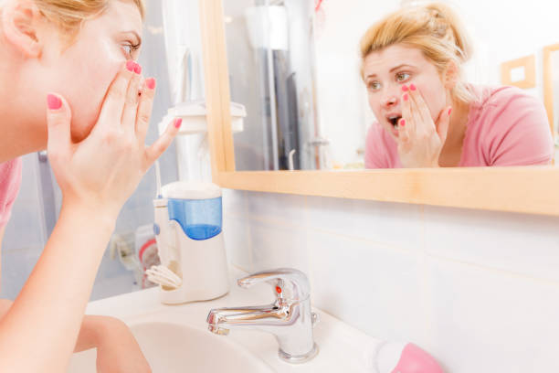 istock Scared woman washing her face under sink 697845890