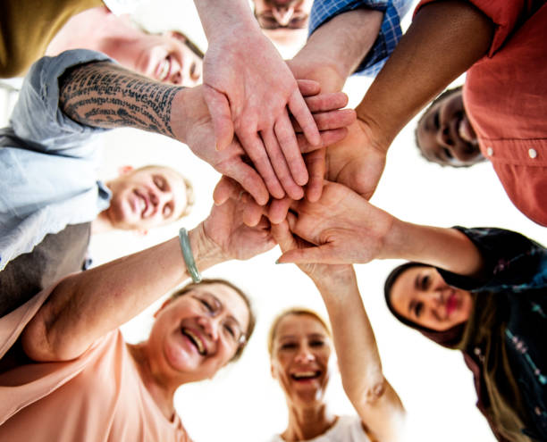 people joining hands together and smiling - 4605 imagens e fotografias de stock