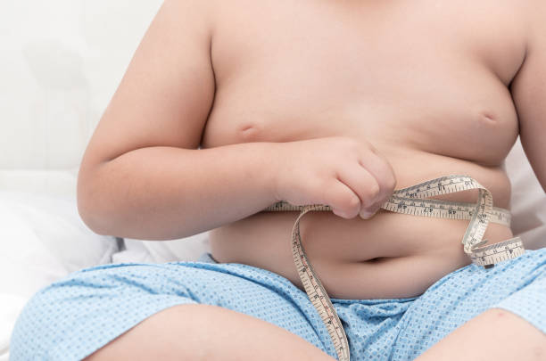 istock Fat boy measuring his belly with measurement tape 697850256