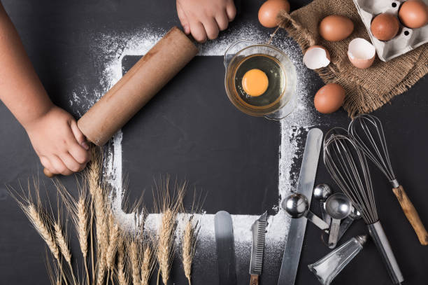 istock little hand with rolling pin and baking utensils 697853806