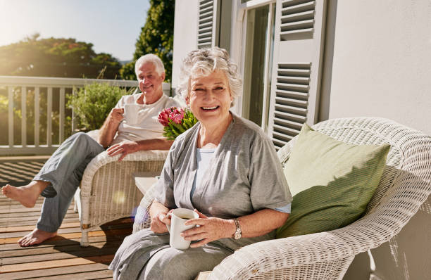 Nothing better than a relaxing retirement Shot of a happy senior woman enjoying some coffee with her husband on the patio at home drinks on the deck stock pictures, royalty-free photos & images