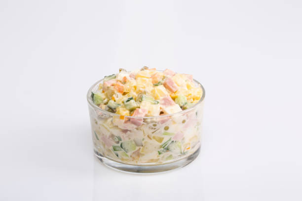 istock Russian salad with olive mayonnaise on white background 697860222