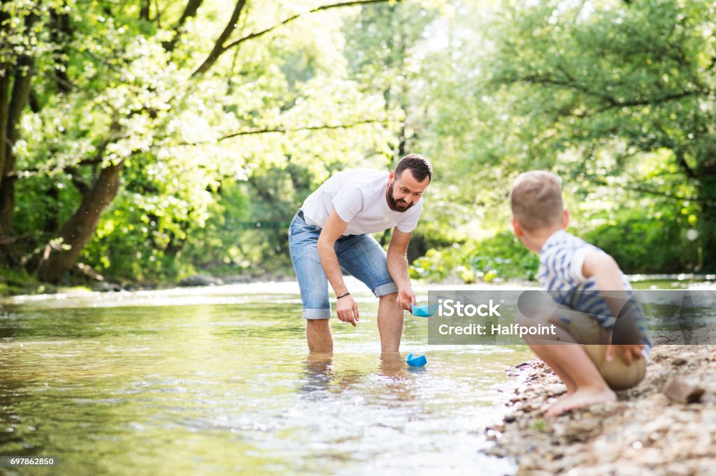 Jovem pai com o filho no rio, dia ensolarado de primavera. - Foto de stock de Criança royalty-free