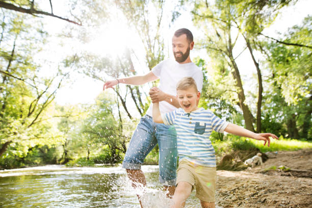istock Young father with little boy in the river, sunny spring day. 697862926