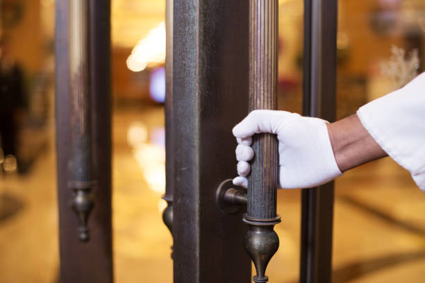 young asian porter with door young indian porter service in luxury hotel lobby door attendant photos stock pictures, royalty-free photos & images