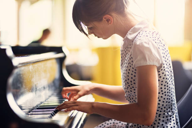 Teenage girl playing piano concert Teenage girl playing concert on an old grand piano. 
 girl playing piano stock pictures, royalty-free photos & images