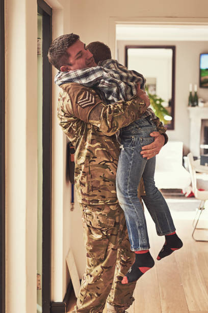 Shot of a little boy welcoming his father home from the army