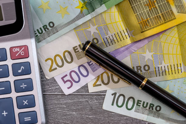 istock calculator with  euro cins and banknotes. macro. 697867710