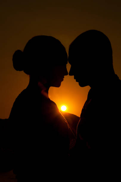 istock Couple in love silhouette during sunset - touching noses 697867724