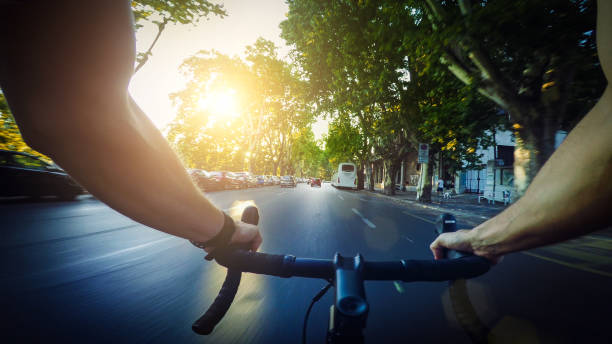 POV commuter riding a road racing bicycle in the city POV commuter riding a road racing bicycle in the city car city urban scene commuter stock pictures, royalty-free photos & images