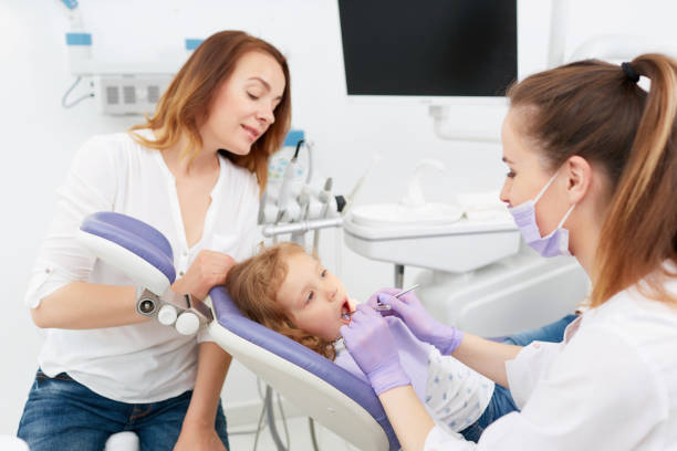 istock Dentists making treatment for little girl 697868542
