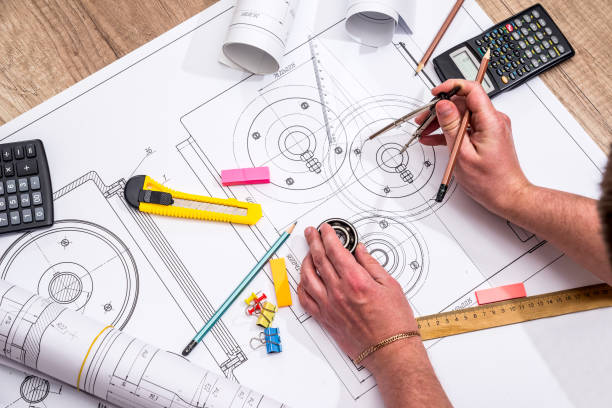 istock engineer measures the dimensions of the drawing. 697872224
